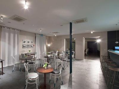 Moderní jídelní prostor a bar se stoly, židlemi a tlumeným osvětlením v hotelu.