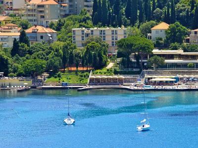Vista di una città costiera con barche sull'acqua blu chiara e edifici sullo sfondo