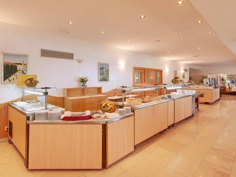 Espace buffet dans un hôtel moderne avec divers plats et éclairage chaleureux.