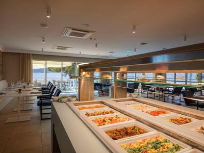Elegant hotelrestaurant met buffet en uitzicht op zee door grote ramen.