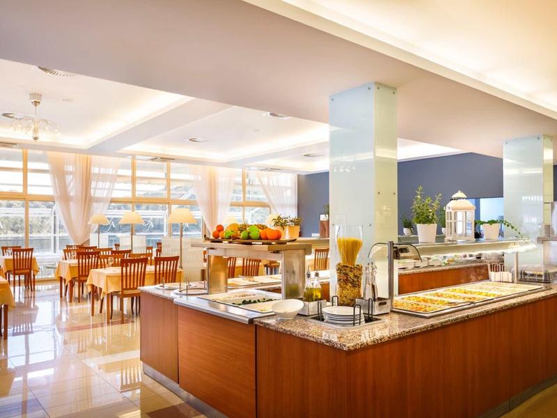 Bright buffet with various fruits and dishes in a modern hotel restaurant.