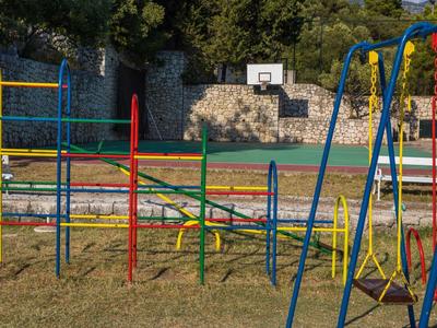 Colorful playground with slides, swings, and an outdoor basketball court.