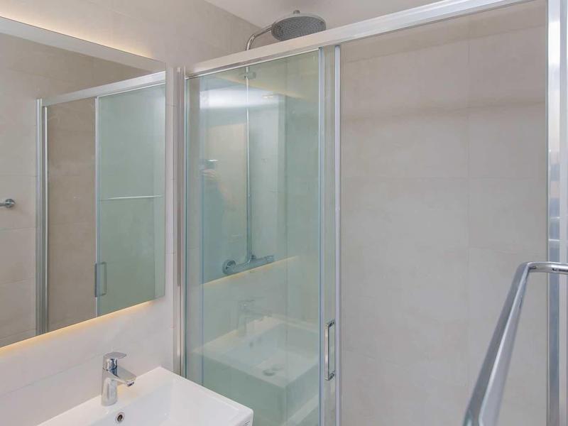 Modern bathroom with rectangular sink and glass shower enclosure.