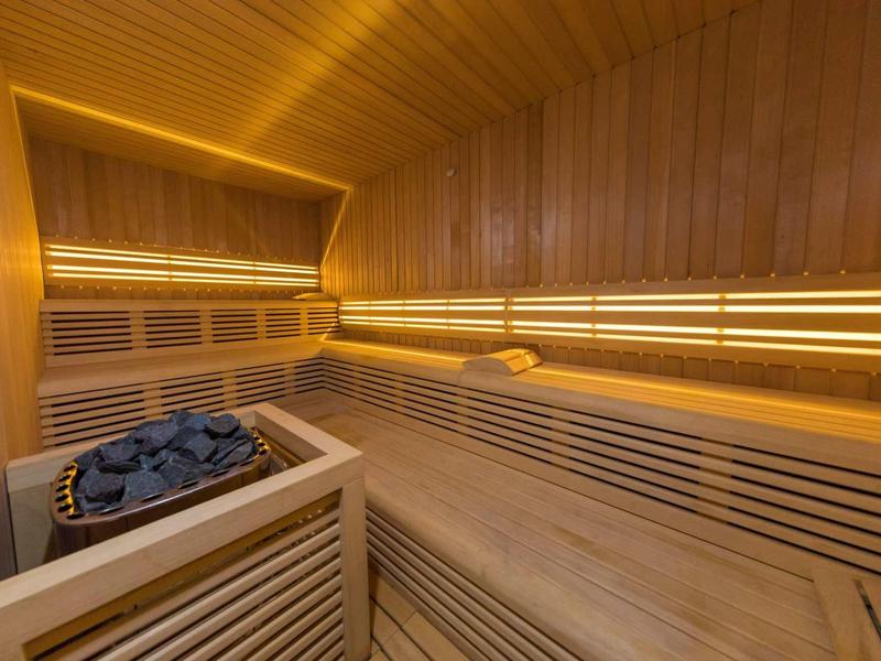 Cozy sauna with wooden benches and stone heater for relaxing wellness moments.