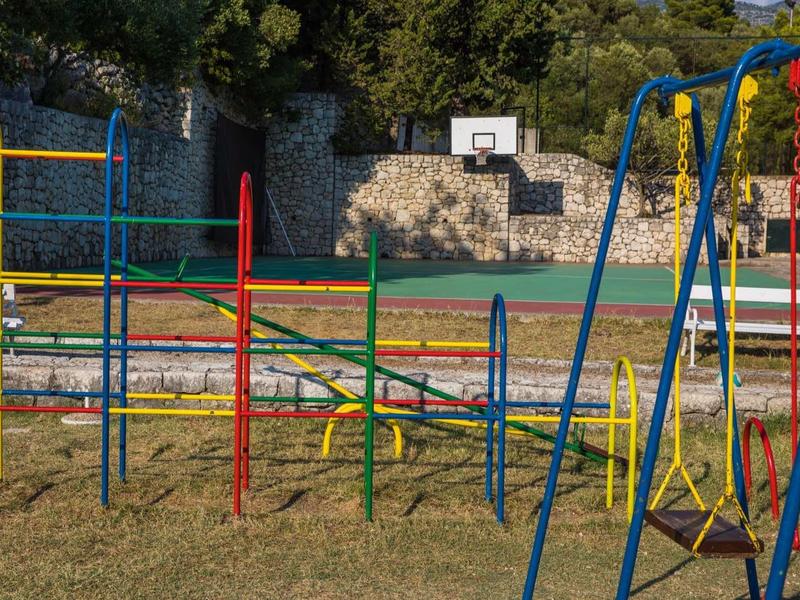 Colorful playground with slides, swings, and an outdoor basketball court.
