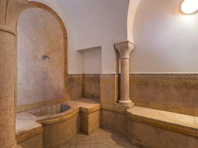 Intérieur d'un espace spa avec carreaux en mosaïque et banc en pierre.