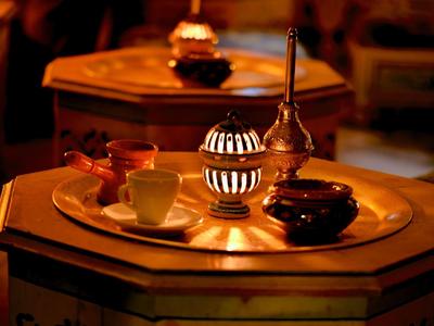 Gemütliches Ambiente mit Kerzenlicht auf einem hölzernen, achteckigen Tisch im warmen Ton.