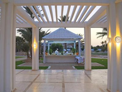 Überdachte Terrasse mit Säulen, Blick auf Garten und Pavillon bei Dämmerung