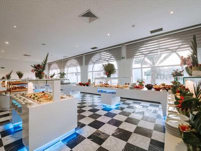 Jasny bufet z kwiatowymi dekoracjami w eleganckiej restauracji z dużymi oknami.