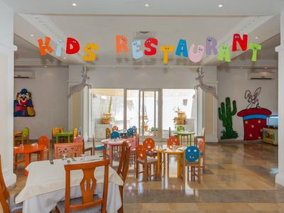 Bunt dekorierter Essbereich für Kinder mit bunten Stühlen und Buchstabenketten.