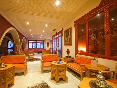 Gemütlicher Wohnzimmerbereich mit marokkanischen Möbeln und warmem Licht.