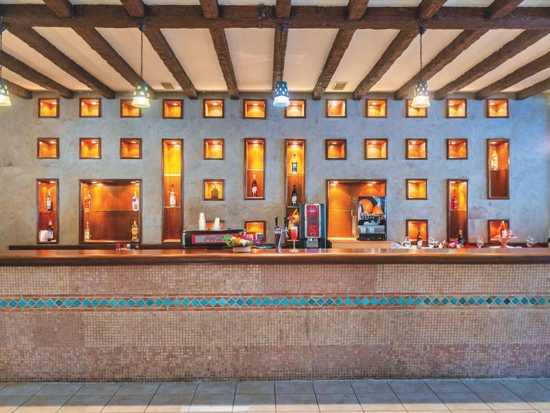 Modern gestalteter Hotel-Empfangsbereich mit warmen Wandlichtern und großem Marmortresen.