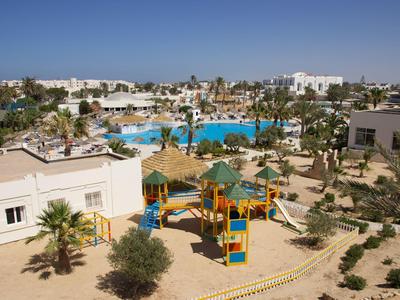 Speelplaats met glijbanen en klimnetten naast een hotelzwembad in een zonnig vakantieoord.