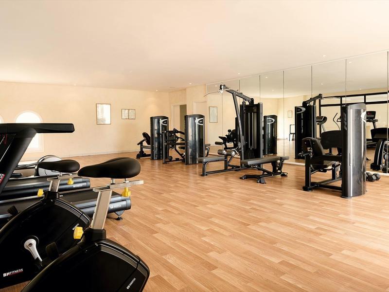 Gimnasio moderno con máquinas de ejercicio y suelo de madera en hotel