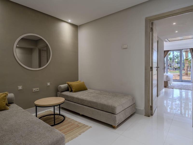 Sala moderna con sofás grises, mesas redondas y decoración minimalista.