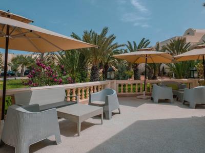 Terasa s moderním posezením a slunečníky před tropickou zahradou