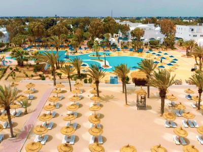 Großer Außenpool mit Sonnenschirmen und Palmen in einem Hotelresort bei sonnigem Wetter.