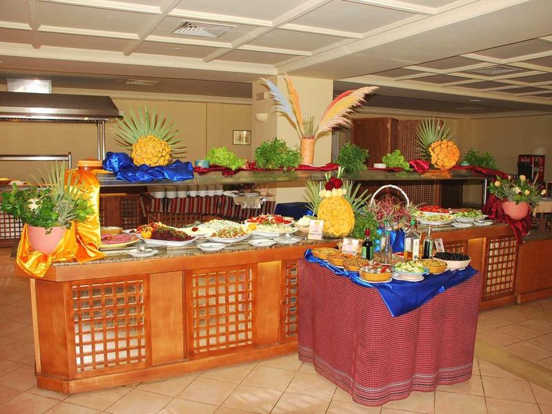 Espace buffet avec présentations de fruits et salades dans un restaurant d'hôtel.