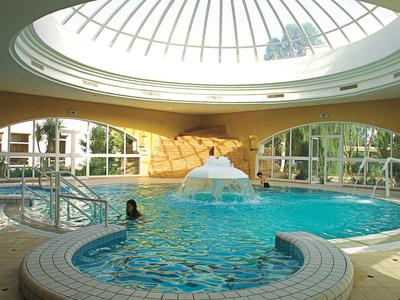 Innenpool mit runder Form, Wasserfontäne in der Mitte und großer Glas-Kuppel über dem Becken.