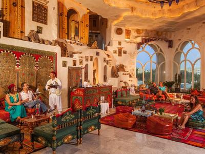 Interno orientale lussuoso con arredi tradizionali e accoglienza degli ospiti.