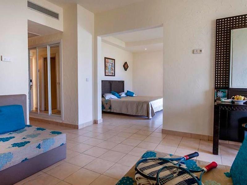 Tavolo apparecchiato con cibo e palme con spiaggia sullo sfondo