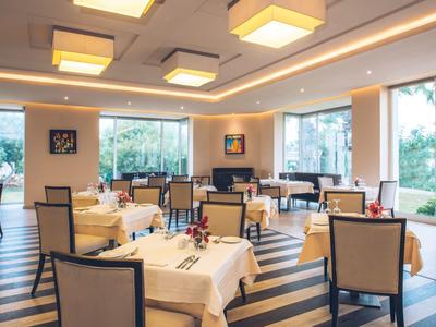 Helles Restaurant mit großen Fenstern, bequemen Stühlen und stilvoll dekorierten Tischen.