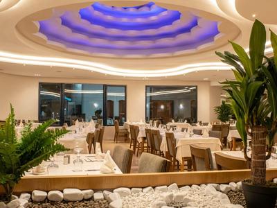 Ristorante elegante con tavoli apparecchiati e soffitto rotondo illuminato di blu