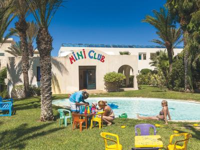 Kinderspielbereich mit bunten Stühlen und einem kleinen Pool vor einem Hotelgebäude mit Palmen.