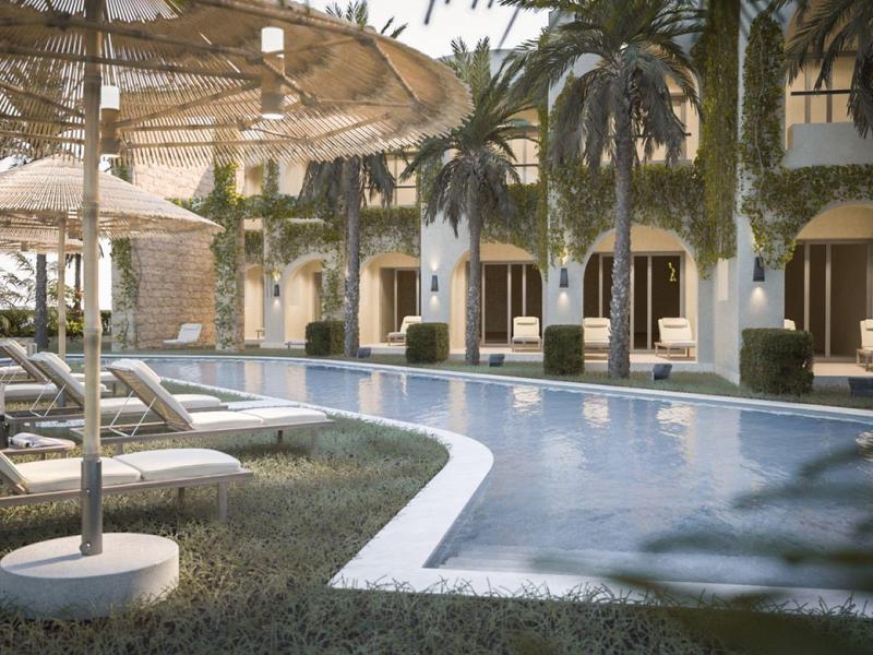 Piscina dell'hotel con lettini, ombrelloni e palme in un resort tranquillo.