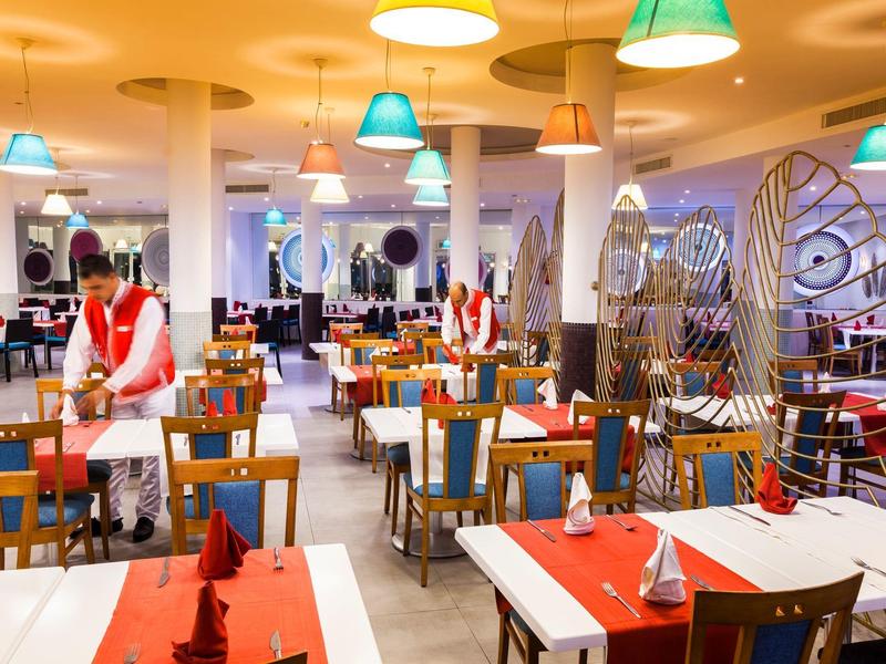 Hell beleuchtetes Restaurant mit dekorativen Lampen und festlich gedeckten Tischen.