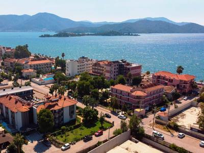 Vue d'une ville côtière avec des hôtels et une baie bleue sous un ciel clair.