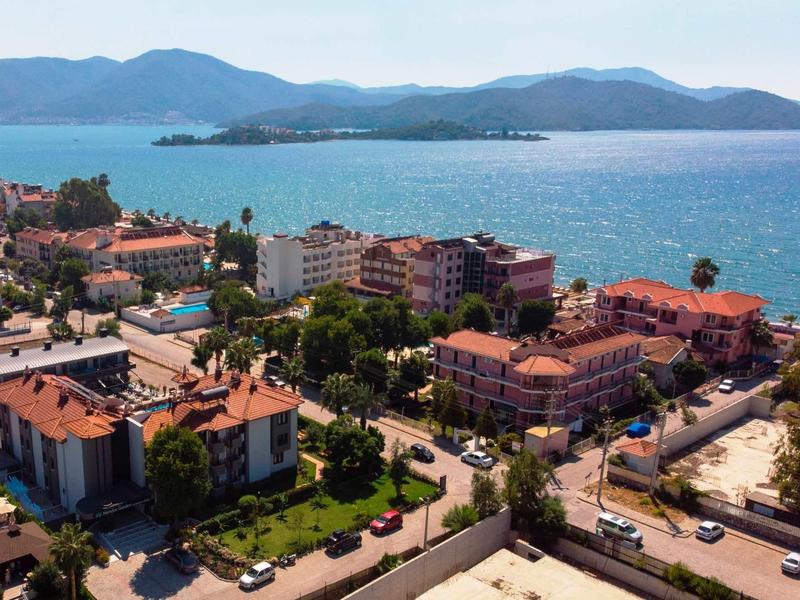 Vue d'une ville côtière avec des hôtels et une baie bleue sous un ciel clair.