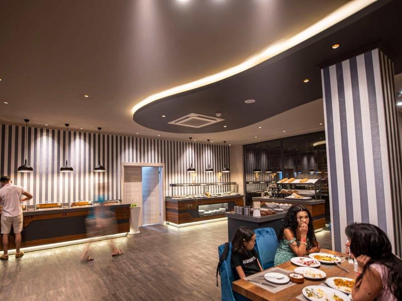 Restaurant d'hôtel moderne avec murs rayés et invités à table.