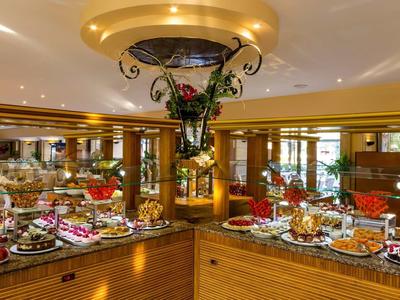 Strefa bufetu z różnorodnymi potrawami i elegancką dekoracją w restauracji hotelowej.