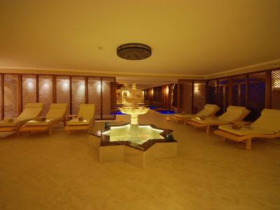 Ein entspannter Spa-Raum mit Liegen und einem zentralen Wasserbrunnen.