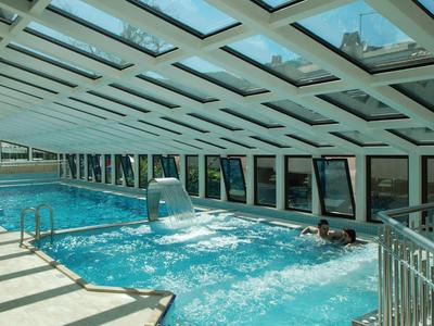 Ogrzewany basen kryty z wodospadem i panoramicznymi oknami w hotelu