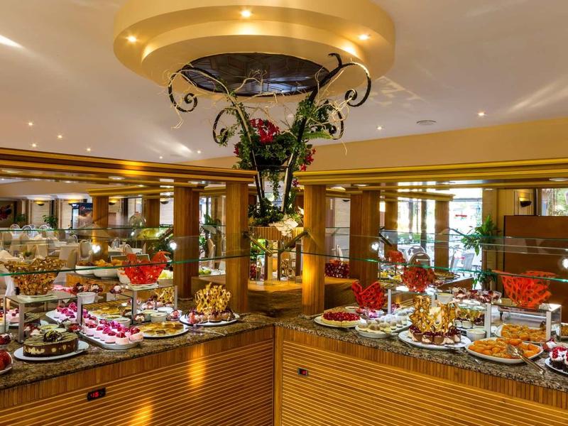 Strefa bufetu z różnorodnymi potrawami i elegancką dekoracją w restauracji hotelowej.