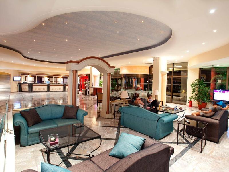 Nowoczesne lobby hotelowe z sofami, szklanymi stolikami i ozdobnym sufitem.