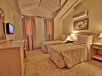 Gemütliches Hotelzimmer mit zwei einzelnen Betten, warmem Licht und Holzmöbeln.