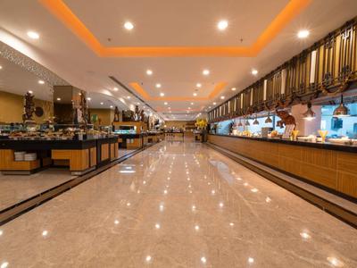 Large, bright hotel dining hall with buffet and modern ceiling lights.