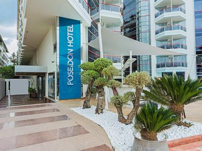 Entrance area of a modern hotel with blue signage and tropical plants.