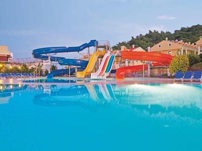 Large pool with water slides and lounge chairs at a hotel resort.