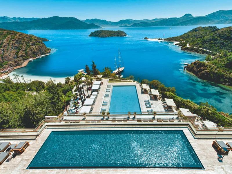 Bazény a terasy s výhledem na moře a zelenou přírodu.