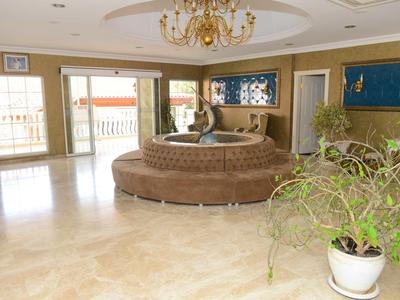 Elegantní hotelová hala s kulatou centrální pohovkou a lustrem