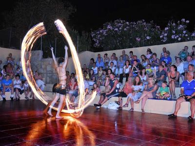 Fire performer executes an impressive outdoor show with fire balls in front of an audience.