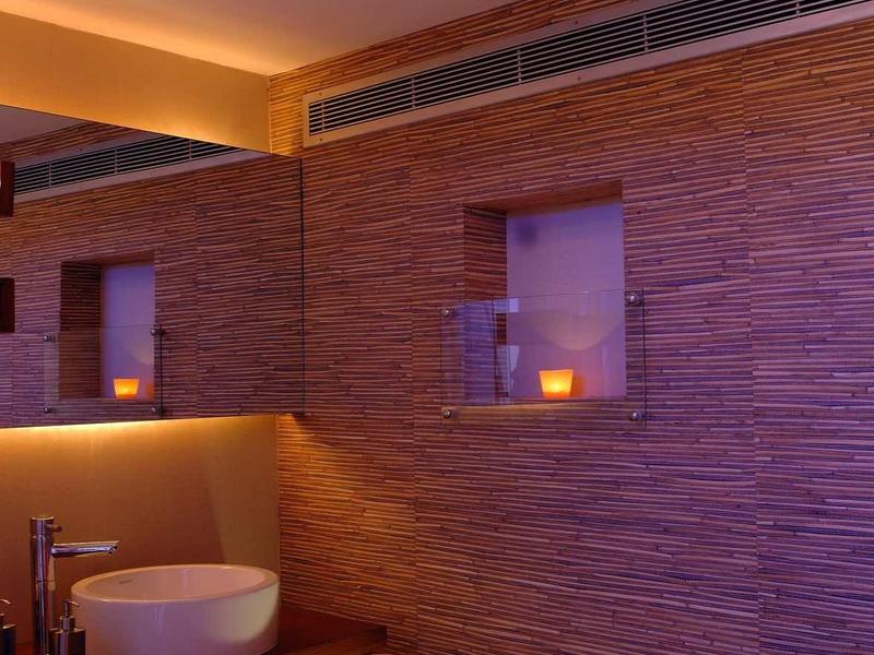 Accogliente stanza benessere con lettino da massaggio, illuminazione soffusa e asciugamani decorativi.