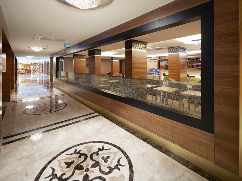 Modern hotel corridor with marble floor and illuminated ceiling light.
