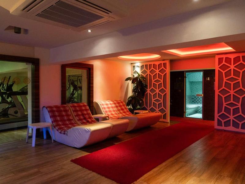 Modern hotel lobby with cozy chairs, red carpet, and warm lighting.