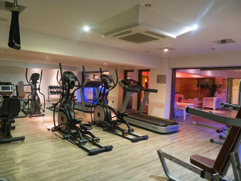 Gym with treadmills, elliptical machines, and modern design near the hotel.