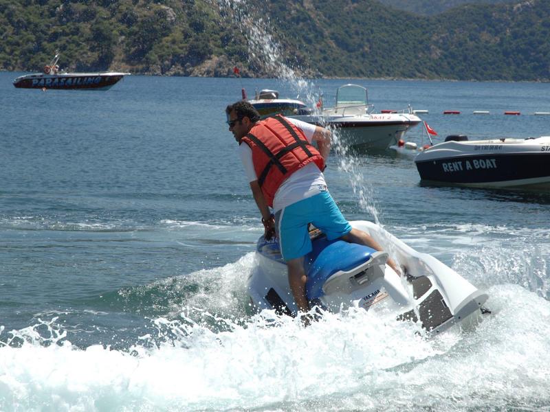 Personne sur un jet ski portant un gilet de sauvetage rouge sur l'eau.